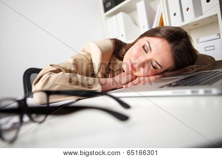 woman fallen asleep while using computer in office