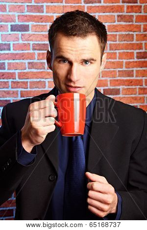 Businessman holds cup of coffee