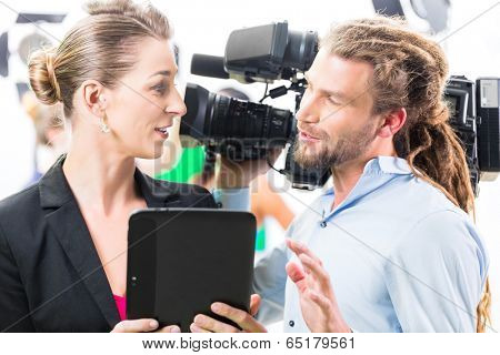 Team discussion or Director giving cameraman scene direction on set of a video production for TV or News 