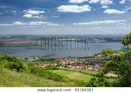 Spring Countryside With Village, Lake, Blue Sky And Clouds