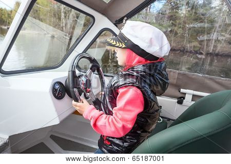 Small Child Driving Motorboat As Captain On Deck