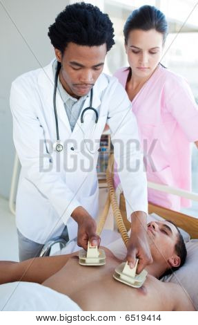 Etnico medico utilizzando un defibrillatore su un paziente