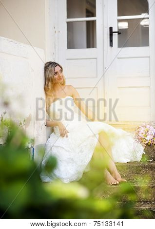 Blonde bride by old house