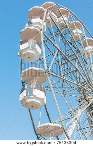 White Ferris Wheel Against Blue Sky Background