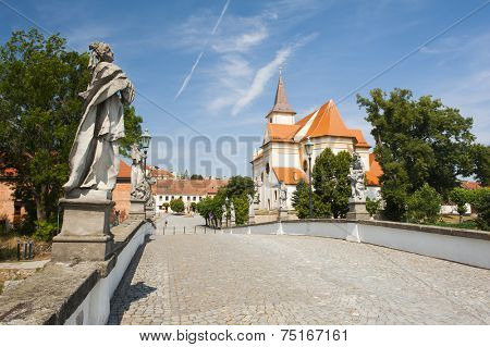 Baroque bridge with statue and a church in Namest nad Oslavou, Czech Republic
