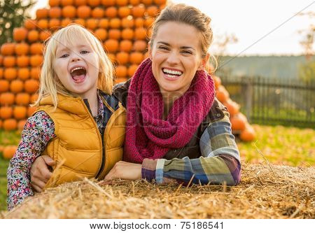 Portrait Of Smiling Mother And Child Near Haystack