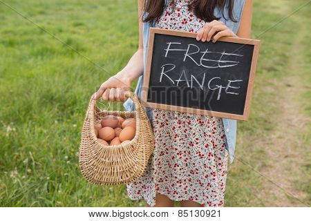 Woman holding basket of free range eggs on a sunny day
