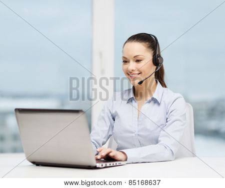 business, communication and call center concept - friendly female helpline operator with headphones and laptop computer