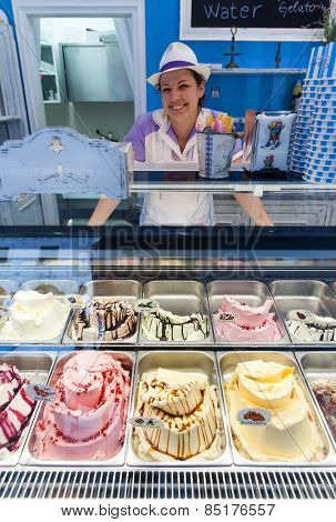 DUBROVNIK, CROATIA - MAY 26, 2014: Smiling young waitress at Gossip ice cream shop on main street Stradun. It is one of the best ice cream place in town popular among tourists.