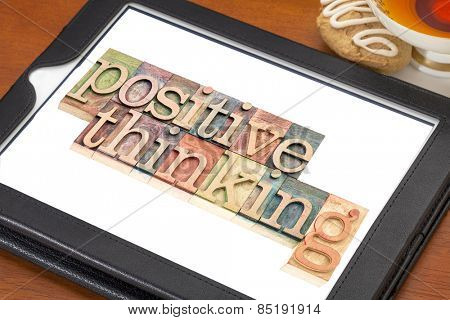 positive thinking typography - isolated text in letterpress wood type blocks on a digital tablet with a cup of tea