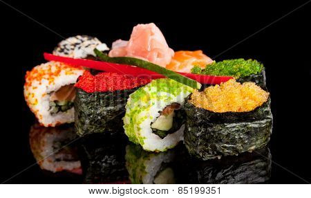 Delicious sushi rolls served on black table