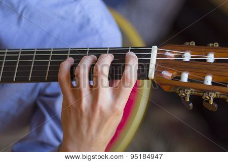 Acoustic Guitar's Fretboard And Young Male's Hand