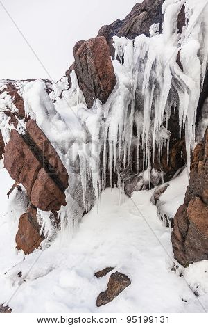 Ice Stalactites On Volcanic Rocks