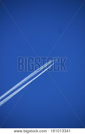 Contrails of a big airplane in a clear blue sky