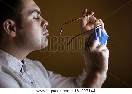 the man wipes with a rag of a lens of computer glasses.