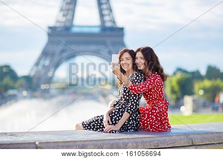 Beautiful Twin Sisters Taking Selfie In Front Of Eiffel Tower