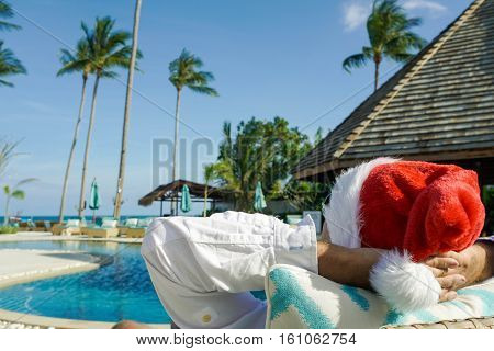 Man in Santa Claus Hat Relaxes by the Pool shot with a Sony a6300