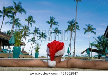 Man in Santa Claus Hat Relaxes in the Pool shot with a Sony a6300