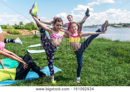 Kids gymnasts warming up in pair outdoors