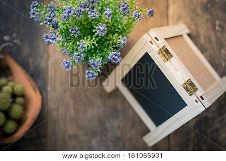 Black Board And Violet Flower, Cactus On Wooden Background