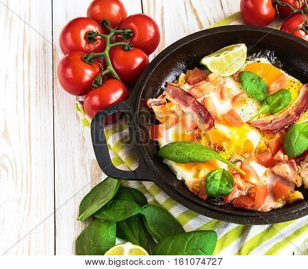 Pan Of Fried Eggs With Tomatoes, Bacon, Spinach, Lime