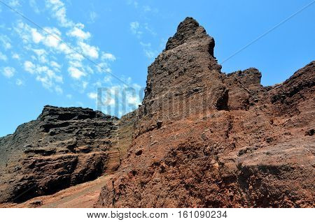 terracotta rock and blue sky background. The famous Red beach, in Santorini island, Greece.