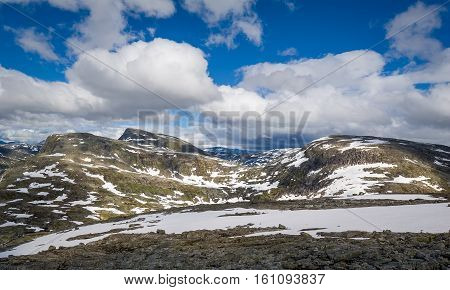 Rocky landscape with snow and sun light. Scenic views from Dalsnibba viewing point. Geiranger, Norway.