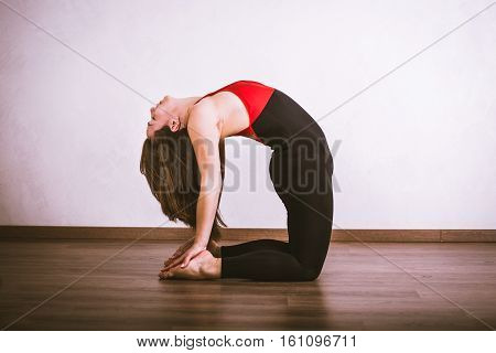 Young pretty woman in black leotard practicing yoga