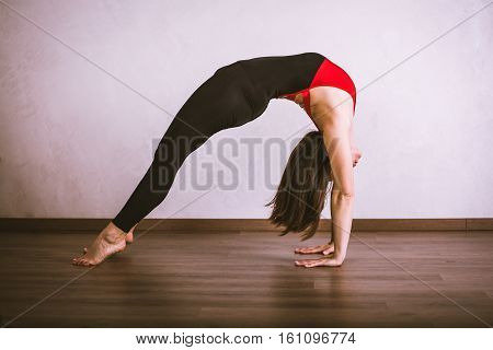 Young pretty woman in black leotard practicing yoga