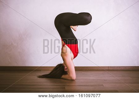 Young pretty woman in black leotard practicing yoga