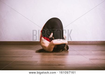 Young pretty woman in black leotard practicing yoga