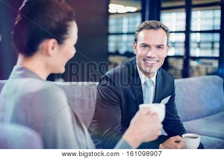 Businessman and businesswoman having a discussion during breaktime in office
