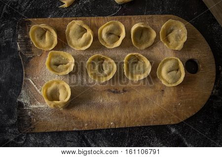 Freshly Prepared Italian Tortellini On Wooden Board