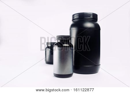 Sport Nutrition Whey Protein and Gainer. Black Plastic Jars isolated on white background