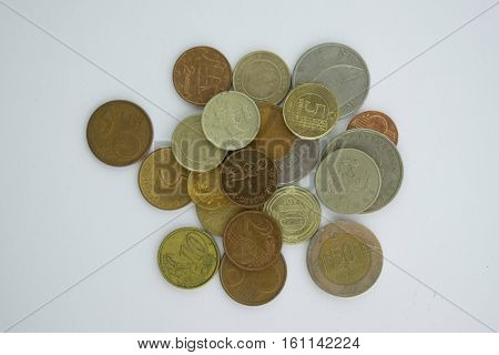 Coins from different europian countries pictured from above on the white background