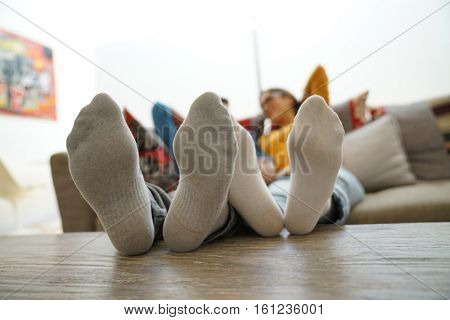 Closeup of couple's feet laid on table