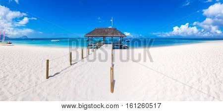 Sandy tropical Wolmar beach at sunny day. Jetty on the foreground.  Mauritius. Panorama