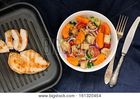 Healthy Salad Bowl With Cuscus, Tomatoes, Cucumber, Chicken, Tangerine And Sesame Seeds