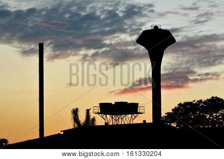 The huge water tower under the cloudy and sky at evening silhouette shadow style .