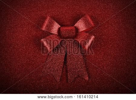 Glittering red ribbon with bow for xmas on sparkly background