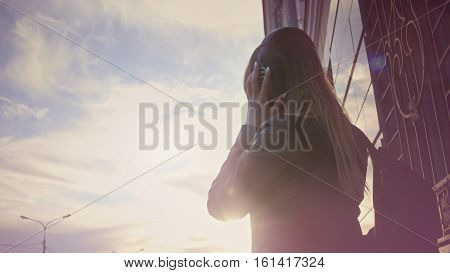 Cute young girl on headphones at sunset, horizontal, pink flas