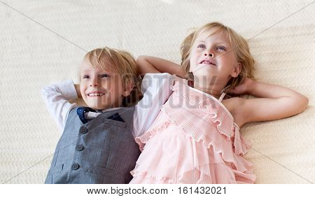 Brother and sister are lying on the floor. Studio shot