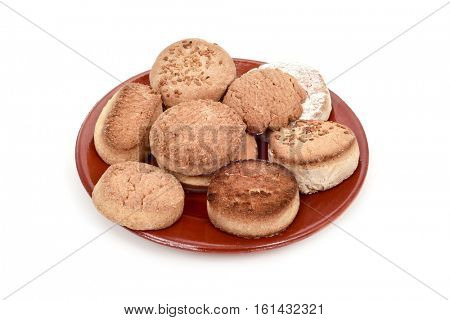 an earthenware plate with different mantecados and polvorones, a typical christmas confection in Spain, on a white background