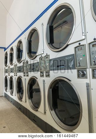 Line of industrial laundry machines in laundrette