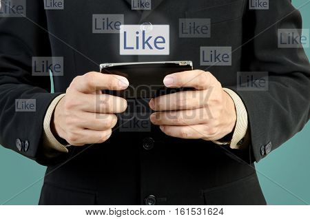 Businessman touch smart phone in hand with like social network
