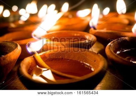 Shots of earthenware lamps filled with oil and with a cotton wick. These diyas are lit during diwali and other celebrations