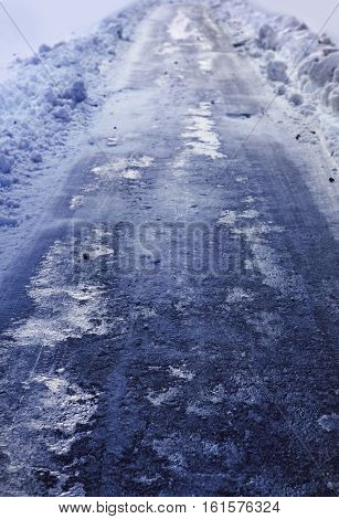 Snow covered winter road with shining streetlights  in rural areas