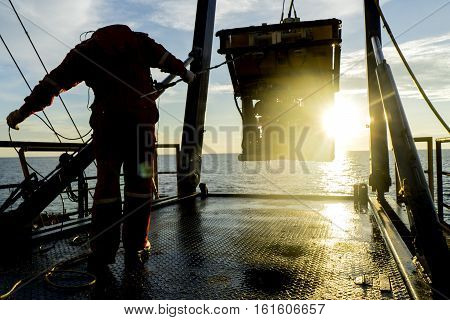 Silhouette Of Worker Recovering Robotics Remote Operated Vehicle (rov) After Entering Sea Surface Du