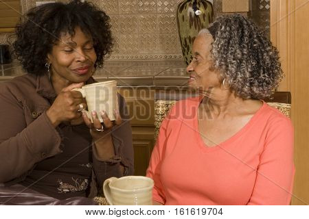 African American mother having coffee with her daughter.