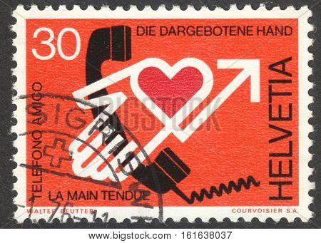MOSCOW RUSSIA - CIRCA NOVEMBER 2016: a post stamp printed in SWITZERLAND shows the proffered hand dedicated to Pastoral Care by Phone circa 1975